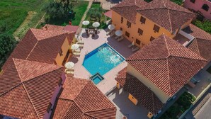 An aerial view of a property with a swimming pool surrounded by outdoor seating and umbrellas, a red-tiled roof, and a garden area. - Residence in Orosei with 2 bedrooms sleeps 6 (Orosei)