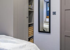 A bedroom with a bed, a wardrobe, a mirror, and a wall socket. - Deluxe modern and contemporary luxury lodge perfect for a relaxing escape. (Workington)