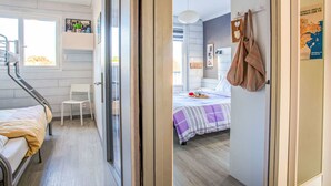 Une pièce avec un lit, une chaise, une fenêtre et une carte accrochée au mur.