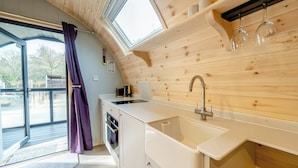 Une cuisine moderne avec des murs en bois, un évier encastré et une fenêtre donnant sur une terrasse.