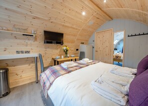 A cozy room with a bed, a desk, a TV, and a mirror. - 1 bedroom accommodation in Wangford, near Southwold (Wangford, near Southwold)