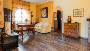 Una sala de estar con una mesa de comedor, un sofá, un aparador y un cuadro en la pared.