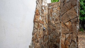Una pared de piedra junto a una pared blanca.