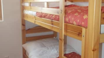 Un lit superposé à deux niveaux, chaque niveau étant équipé d’un oreiller et d’une couverture.