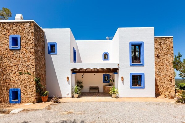 Un bâtiment moderne doté d’une façade en pierre, de nombreuses fenêtres et d’une entrée abritée.
