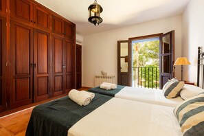 A hotel room with two beds, wooden wardrobe, and a balcony with a view. - Villa 'San Miguel Park' with Mountain View, Private Pool and Wi-Fi (Ibiza Town)