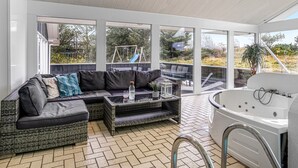 A modern outdoor living area with a sofa, coffee table, and a hot tub. - "Caya" - 750m from the sea by Interhome (Løkken)