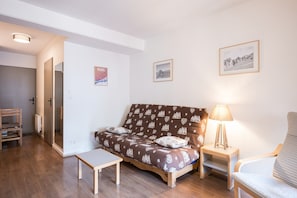 Uma sala de estar moderna com um sofá, uma mesinha, uma cadeira e um abajur.