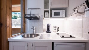 A kitchen with a sink, a coffee maker, a microwave, and a toaster.