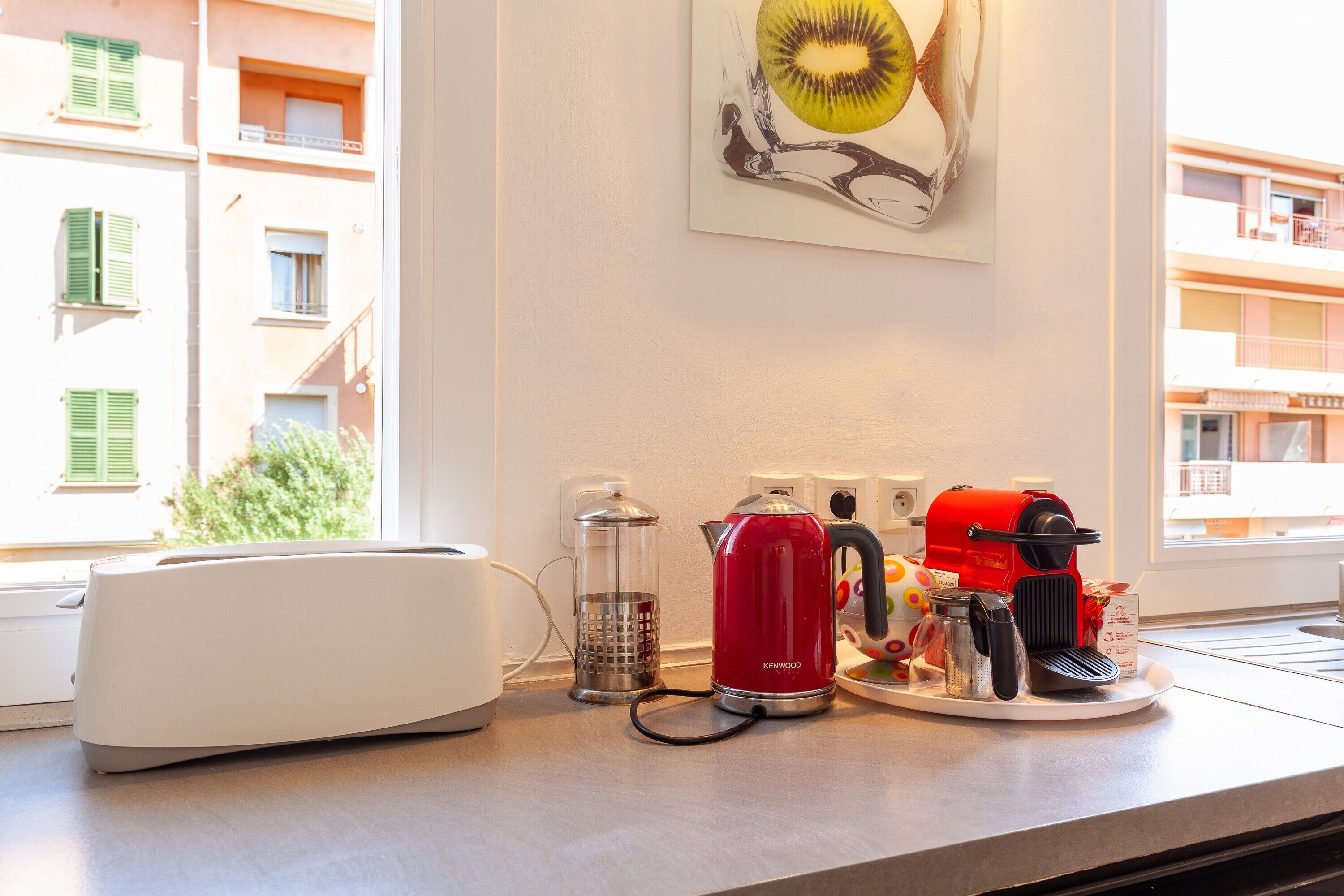Eine Küchenarbeitsplatte mit Kaffeemaschine, Wasserkocher, Lebensmittelschneider und Entsafter.