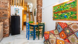 A dining area with a table, chairs, and a refrigerator.