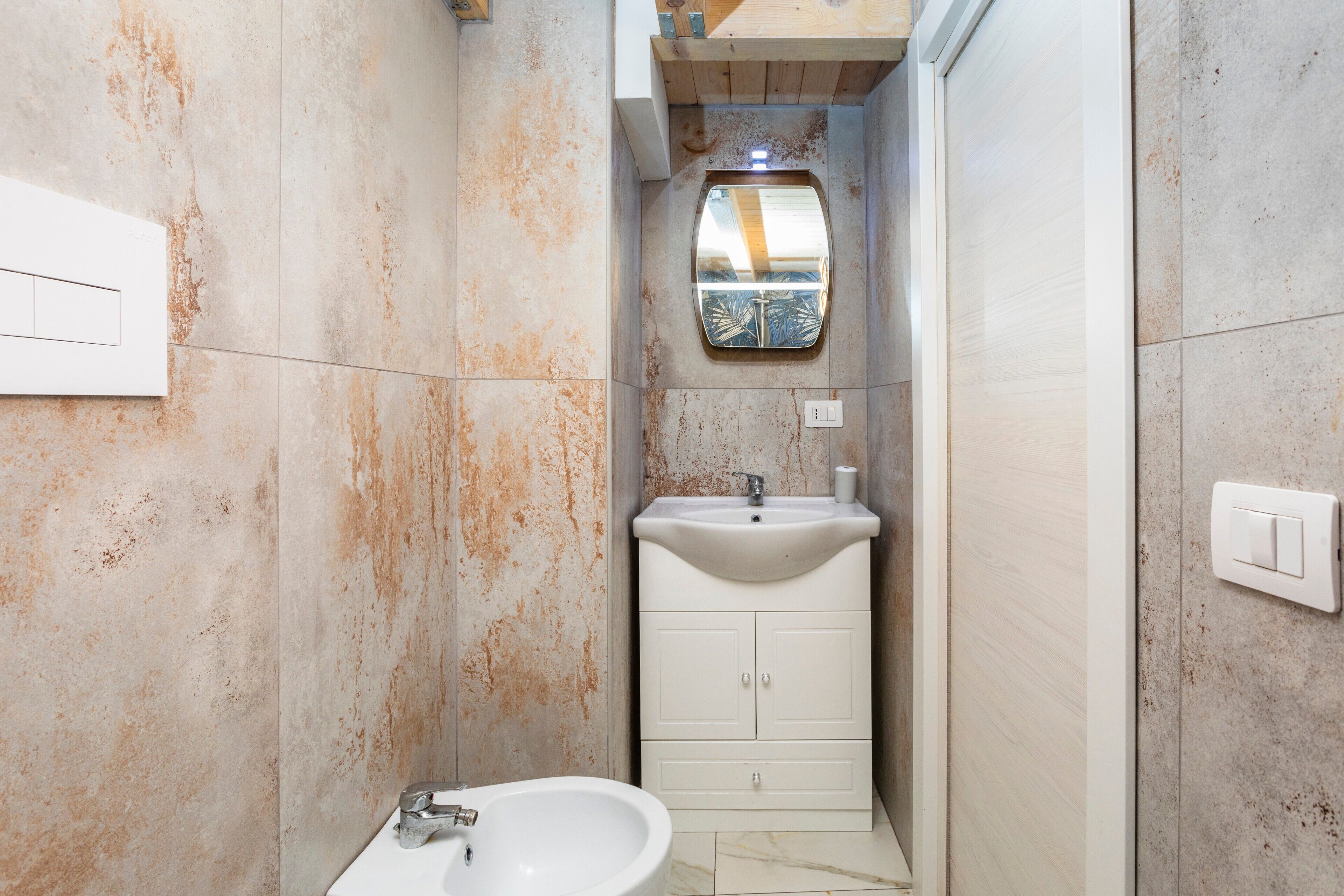 A bathroom with a sink, mirror, and cabinet.