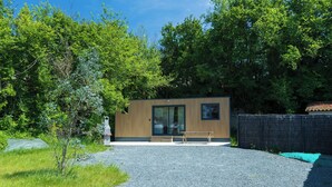 A modern building with a gravel driveway and a wooden bench. - La tiny T Loches, close to Beauval Zoo and the Châteaux. (Loches)