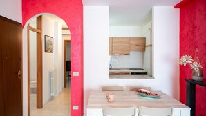 A dining area with a table, chairs, and a vase of flowers. - Apartment 'Di Titina' with Private Terrace and Air Conditioning (Otranto)