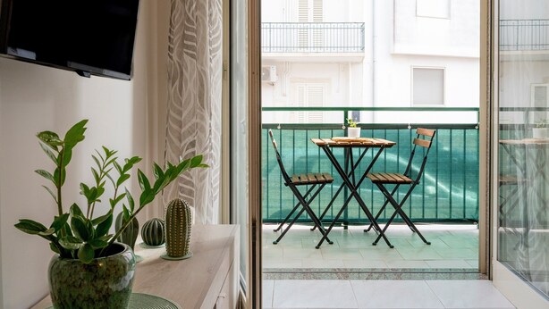 A balcony with a table and chairs, a potted plant, and a cactus. - Apartment 'Di Titina' with Private Terrace and Air Conditioning (Otranto)