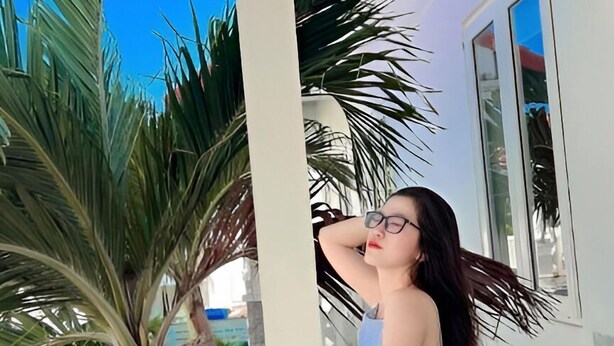 A person standing on a white porch with a view of palm trees and a clear blue sky. - Volga Hotel Mui Ne (Mui Ne)