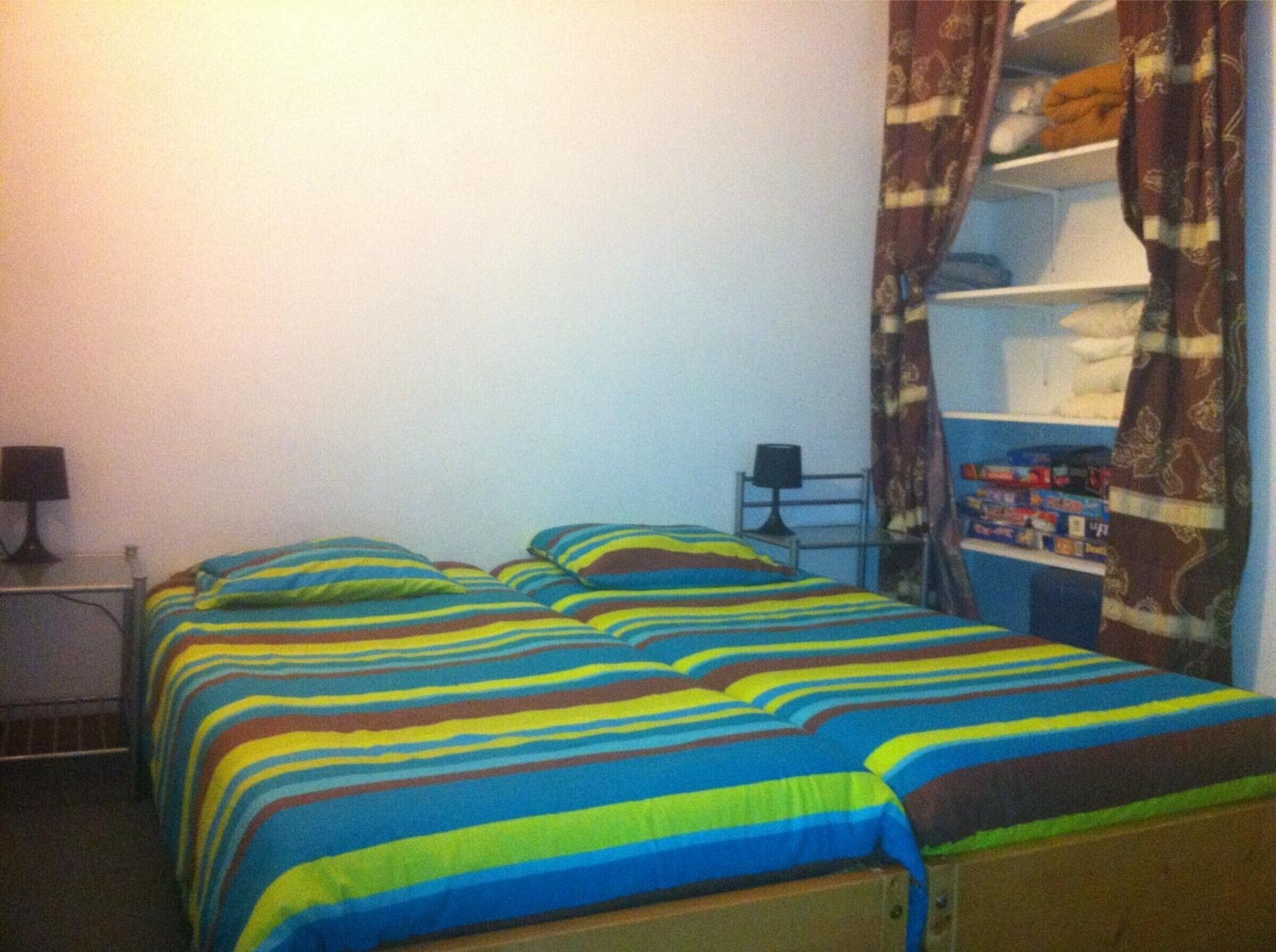 Une pièce comprenant un lit, un bureau et une étagère avec divers objets.