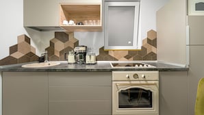 A kitchen with a double sink, a built-in oven, and a coffee maker. - Amazon Apartment - Cismigiu Gardens for 2 guests (București)