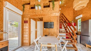 Un intérieur en bois comprenant une table à manger, des chaises, un téléviseur et un escalier.