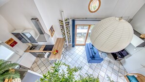 Een moderne keuken met een eethoek, een groot raam en een hanglamp.