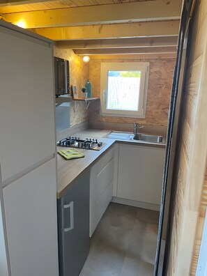 A compact kitchen with a gas stove, sink, and a window providing natural light.