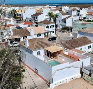 Un quartier résidentiel avec des bâtiments blancs, une piscine et une vue sur la mer.