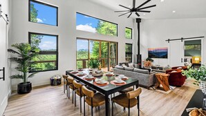 A spacious living area with a large dining table, comfortable seating, and a fireplace.