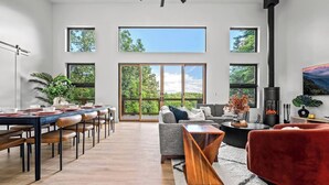 A spacious living area with a dining table, sofas, and a fireplace.
