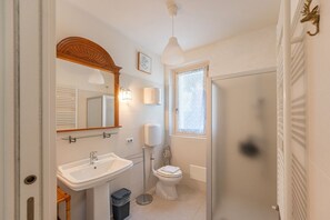 A bathroom with a sink, toilet, and shower.