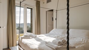 A hotel room with a bed, curtains, a window, and a door. - Villa 'Loft' with Shared Pool, Wi-Fi and Air Conditioning (Cortona)