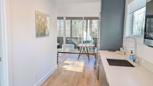 Una cocina moderna con un ventanal grande, un comedor con mesa y sillas, y vistas al exterior.
