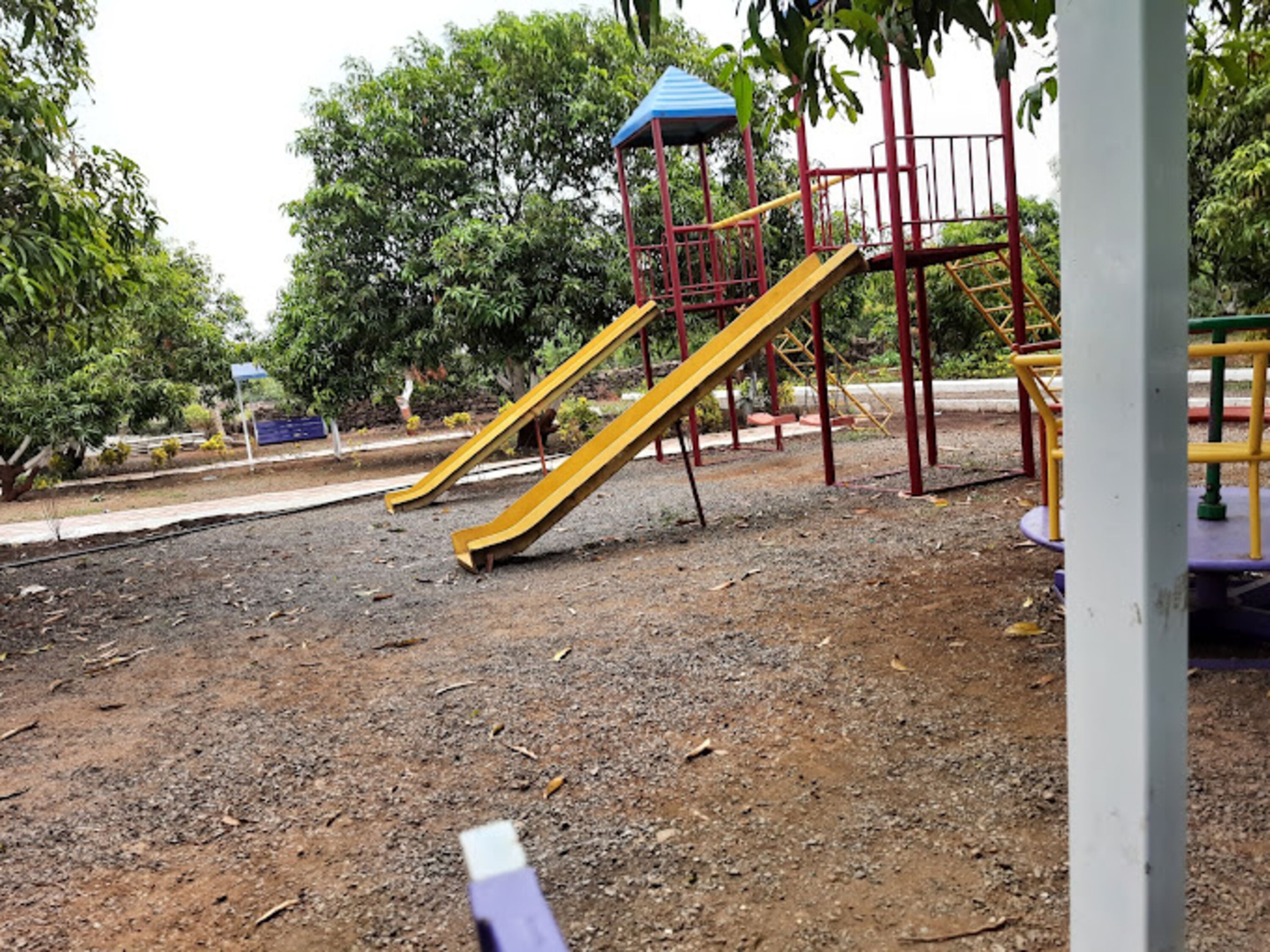A playground with yellow slides and a blue-roofed structure.