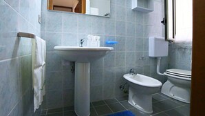 A bathroom with a pedestal sink, a bidet, and a toilet. - Casa Doralucia - Confortevole Casa Vacanze A Santa Maria Di Leuca (Castrignano del Capo)