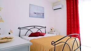 A bedroom with a bed, bedside table, and a wall-mounted air conditioner. - Casa Doralucia - Confortevole Casa Vacanze A Santa Maria Di Leuca (Castrignano del Capo)