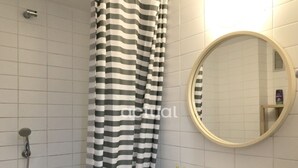 Une salle de bain avec une douche, un lavabo et un miroir.