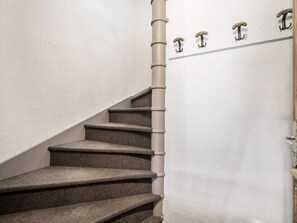 A staircase with a handrail and a door with a handle. - 62m² Duplex near slopes with wellness area & wifi (Val Thorens)