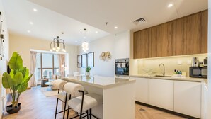 Une cuisine moderne avec un îlot central, des tabourets de bar et une grande fenêtre.