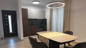 A modern kitchen with dark wooden cabinets, a black countertop, and a built-in oven. - Apartments Robi 2 (Rovinj)