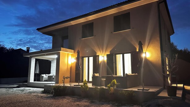A modern two-story house with a covered patio area, large windows, and outdoor lighting. - Apartments Robi 2 (Rovinj)