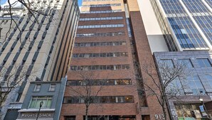 A multi-story building with a brick facade and large windows.
