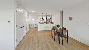 A modern kitchen with white cabinets, a central island, and pendant lighting.