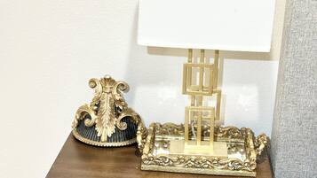 A wooden nightstand with a lamp and decorative items.