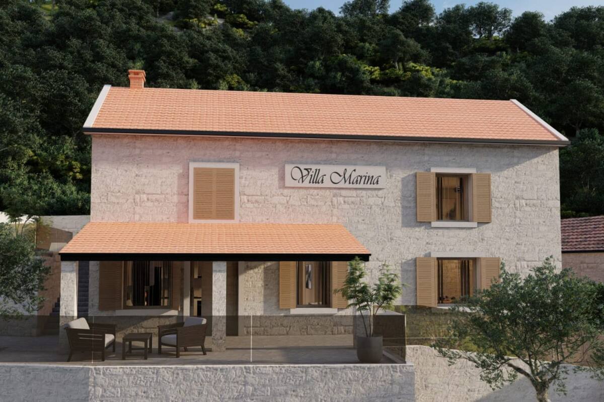 A two-story stone building with a tiled roof, named "Villa Marina." It features a covered patio with outdoor furniture and a potted plant.