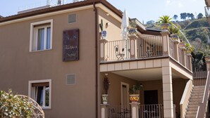 A building with a balcony, potted plants, and a sign that reads "Alison Open". - B&B Allison Tropea (Tropea)