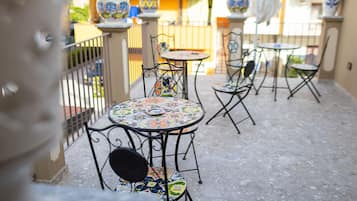 Un patio con tavoli e sedie rotonde, decorazioni da esterno e vista sulla zona circostante.
