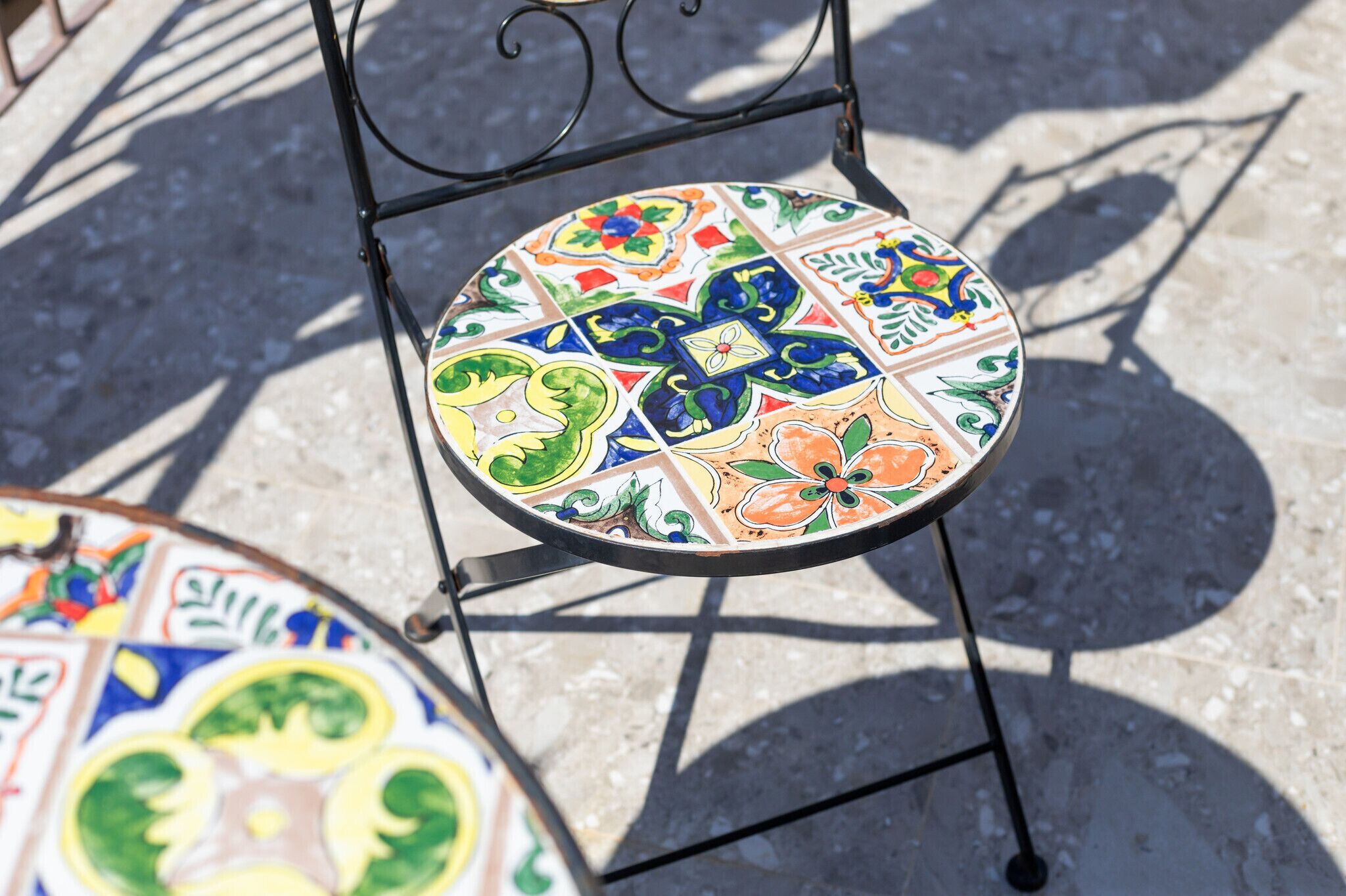 A chair with a colorful, patterned seat and a metal frame.