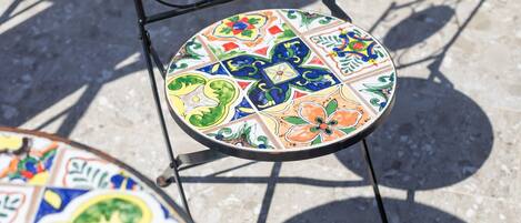 A chair with a colorful, patterned seat and a metal frame.