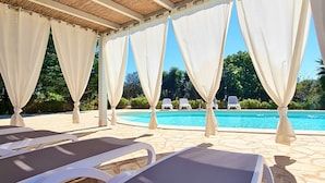 A poolside area with white canopies, lounge chairs, and a clear view of the pool. - Villa Velisia - Con Ampia Piscina E Campo Da Gioco Privato (Alessano)