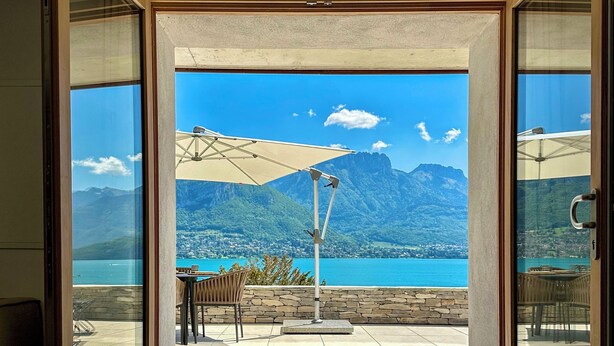 A room with a large sliding glass door leading to an outdoor terrace with a mountain view. - APARTMENT with private terrace & lake view / 200 meters from lake & bike path (Sévrier)