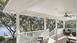 A covered outdoor deck with white railings, wooden flooring, and two wicker chairs. - Lake escape w/ kayaks, bikes & 5-min beach (Santa Rosa Beach)